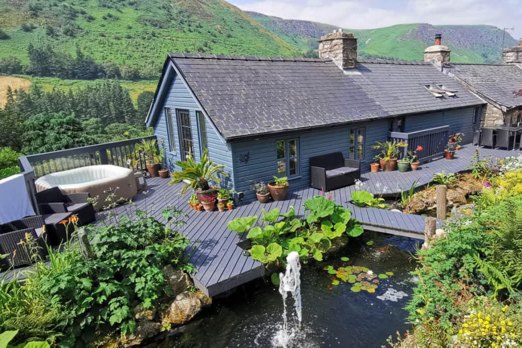 Original deck restored, leveled, enlarged & painted for outdoor living on a mountainside in mod Wales by Turtle Productions